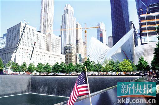 ■“9·11”遗址,水池边上多了一面美国国旗,一名男子指着水池边上的名字对身旁的孩子说,“这些人都是英雄。”