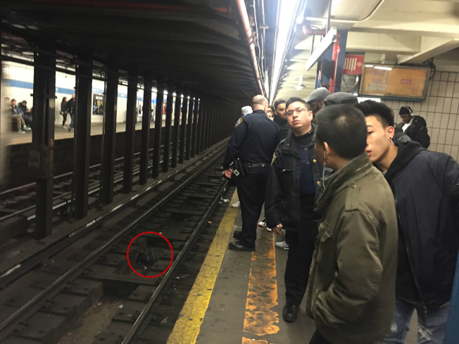 醉汉在华埠地铁调戏华妇,满脸鲜血地在月台追逐乘客,企图推人落轨。圆圈处为见义勇为的法国青年的背包被该醉汉在混乱中扔到铁轨上。(记者高梦梓/摄影)