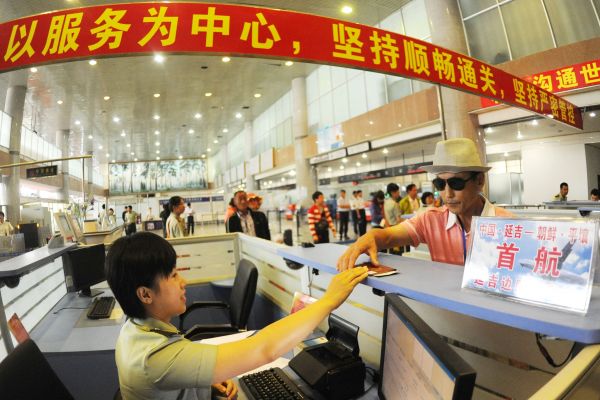 图说:资料图片:2012年7月12日,边防检查员验放赴朝鲜游客出境。新华社发