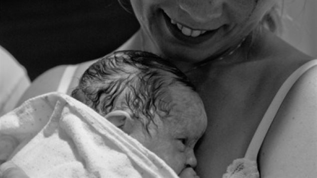 挪威妇女Hilde Reva怀里抱着代孕出生的女婴