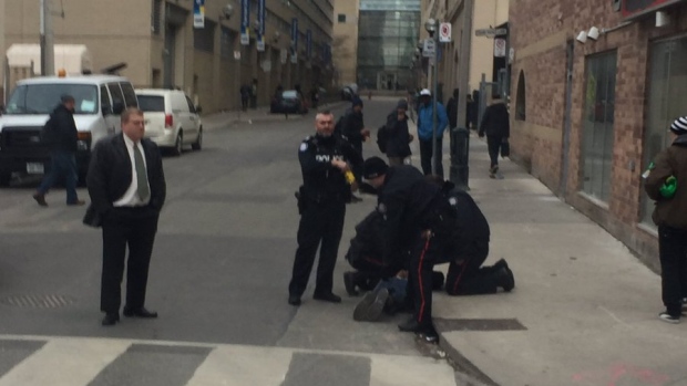 Police are shown arresting a man near Dundas and Church streets on Tuesday morning. (Submitted)