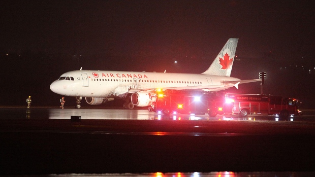 Air Canada flight 623 from Halifax sits on the runway. The plane can be seen with mud on its side.