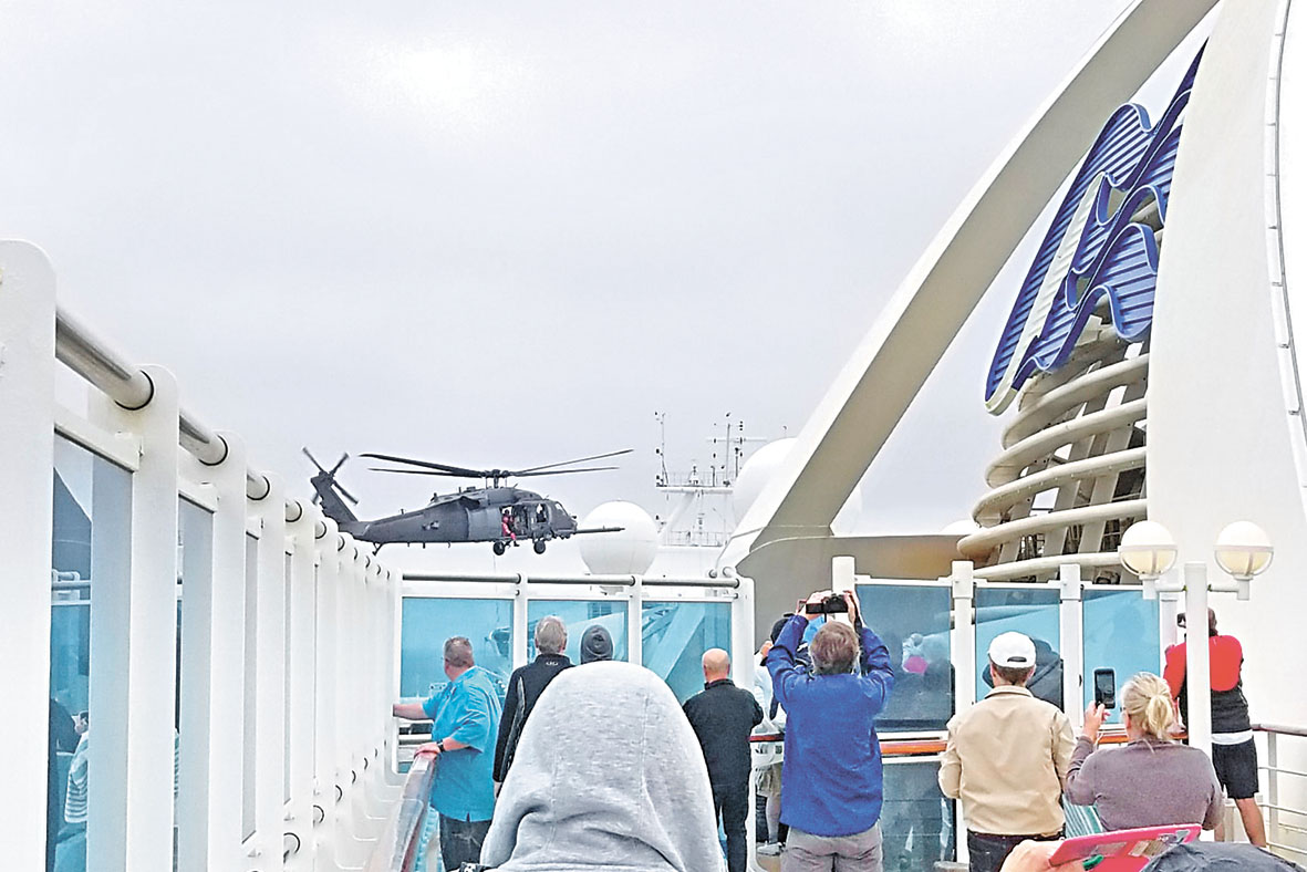 邮轮上的乘客观看直升机行动。美联社