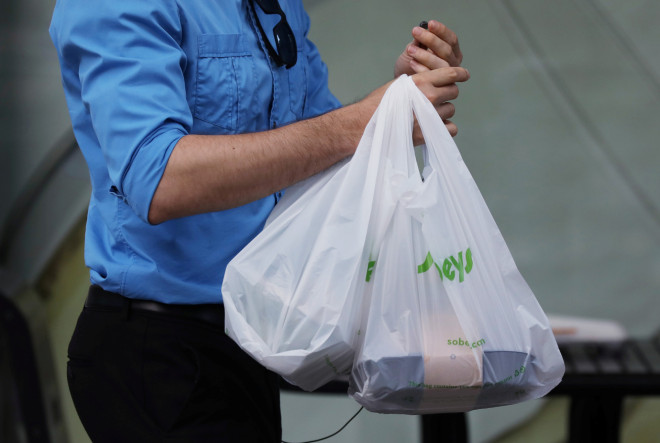 A customer leaves a Sobeys grocery store carrying plastic bags in Ottawa
