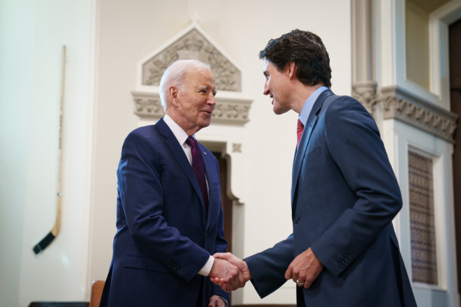 Prime Minister Justin Trudeau and President Joe Biden are standing in the Prime Minister’s West Block office. They are shaking hands and smiling.