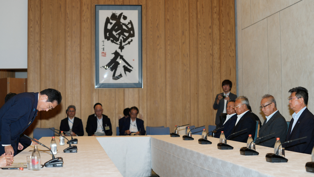 日揆岸田文雄(左)昨在官邸与全渔联会长坂本雅信(右一)等代表会面,谋求他们理解、支持核废水排海。路透社