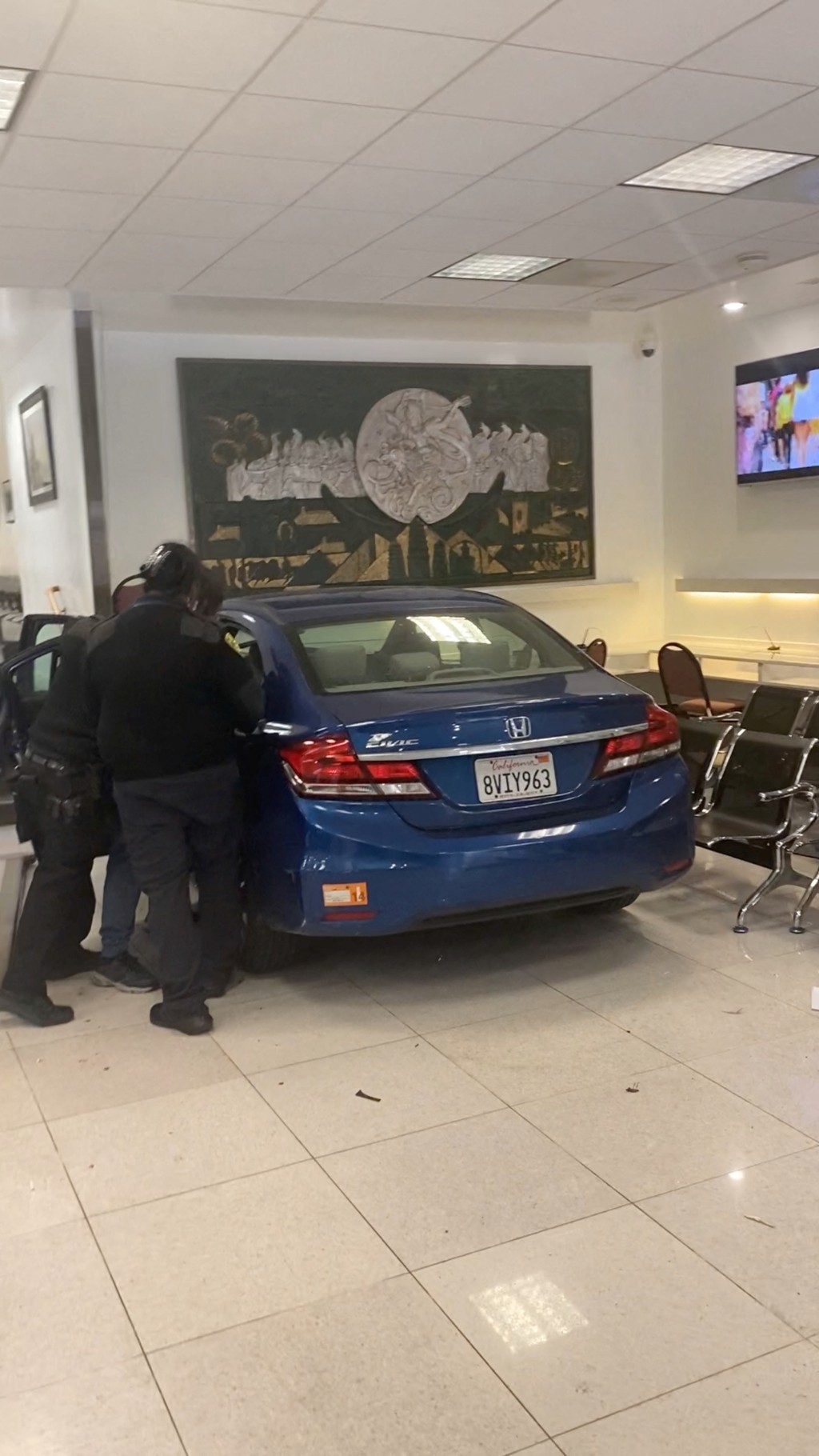 撞入中国总领事馆领事馆证件大厅的蓝色私家车。路透社