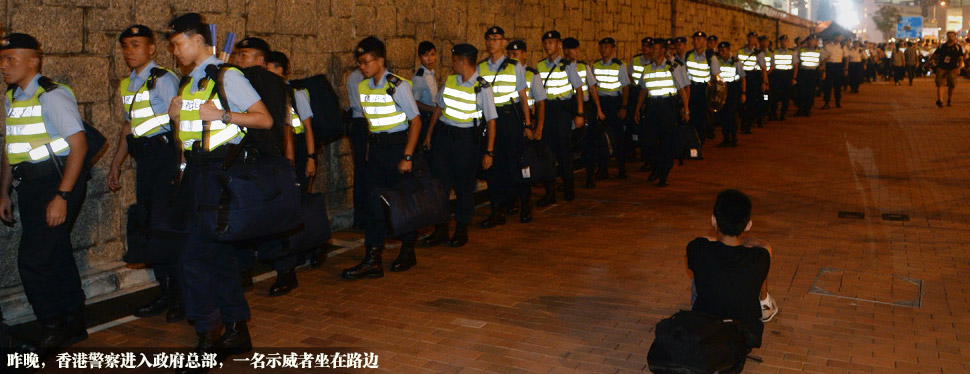 昨晚，香港警察进入政府总部，一名示威者坐在路边