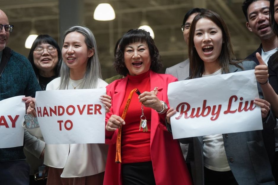 亿万富翁Ruby Liu（中）与她的员工在2025年6月26日于卑诗省Tsawwassen的Tsawwassen Mills购物中心举行的交接仪式上，手持一套曾由Hudson's Bay拥有的Saks Off 5th百货商店的钥匙。 THE CANADIAN PRESS/Darryl Dyck